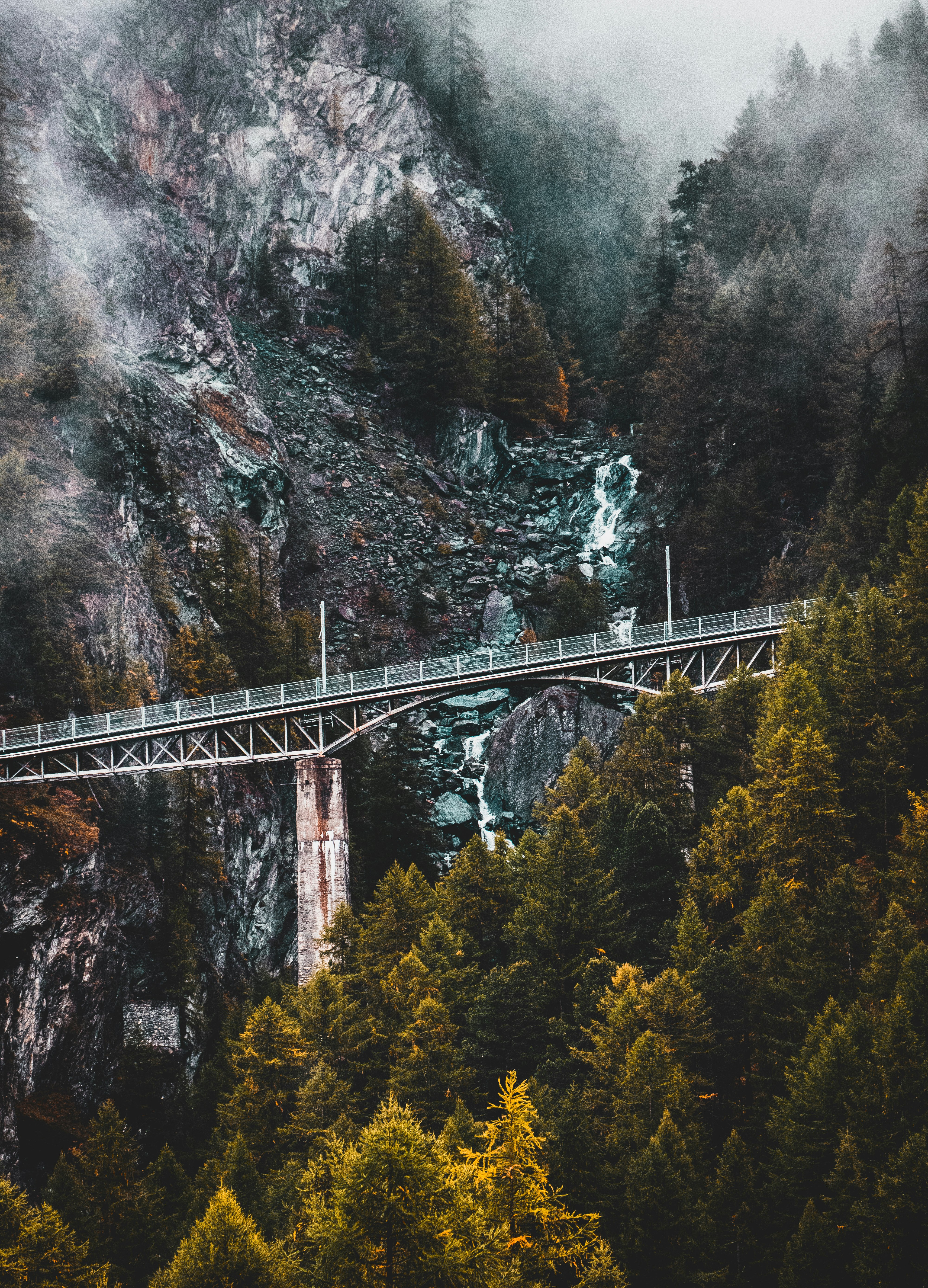 gray suspension bridge near rock formation